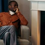 man sitting by fireplace